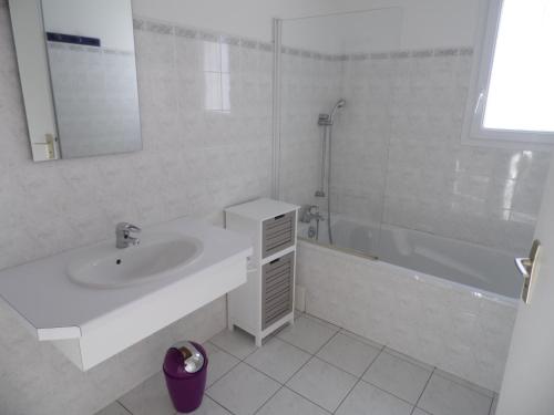 a white bathroom with a sink and a shower at Maison proche plage et centre de La Faute-sur-Mer - FR-1-194-314 in La Faute-sur-Mer
