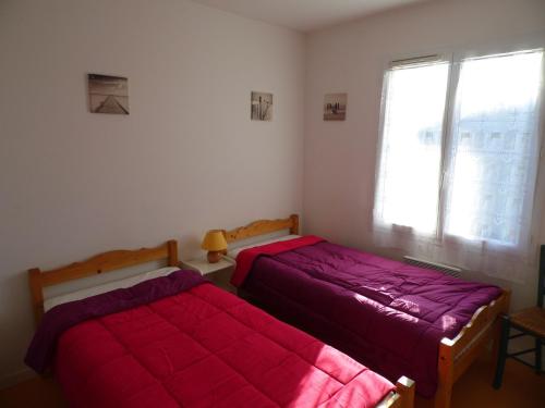 two beds sitting in a bedroom with a window at Maison proche plage et centre de La Faute-sur-Mer - FR-1-194-314 in La Faute-sur-Mer