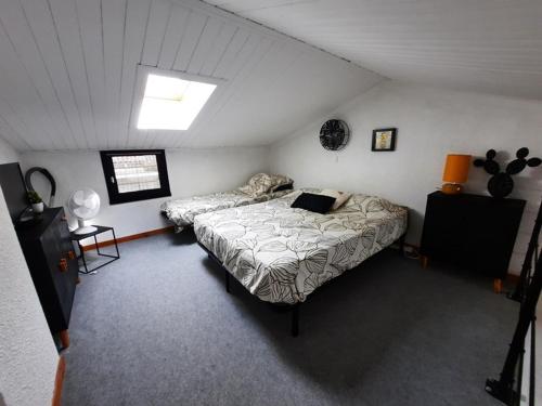 a bedroom with two beds in a attic at Maisonnette rénovée proche plage avec animaux acceptés et parking - FR-1-194-319 in La Faute-sur-Mer