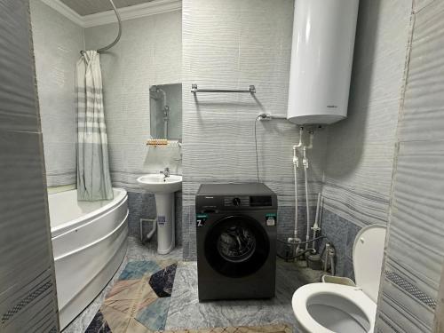 a small bathroom with a washing machine in it at Apartment Nabi Bobo in Samarkand