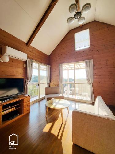 a living room with a couch and a tv at Simple Island Villa Surrounded by Nature Peaceful Stay in Bizen