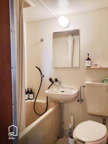 a bathroom with a sink and a toilet and a bath tub at Simple Island Villa Surrounded by Nature Peaceful Stay in Bizen