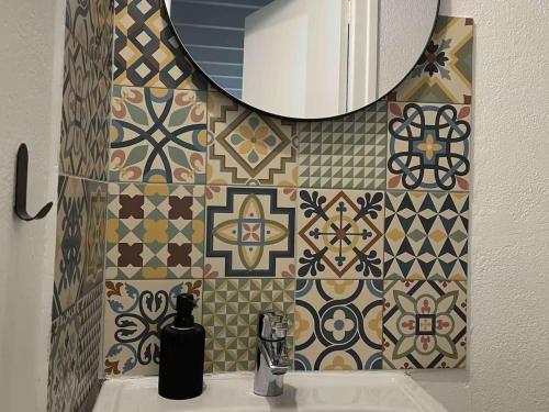 un bagno con un lavandino e uno specchio su una parete di Maison de pêcheur cosy à Sarzeau pour 5 pers. avec jardin privé et parking. - FR-1-639-155 a Brillac