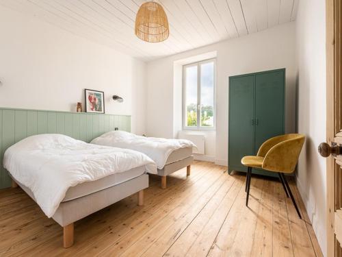 a bedroom with two beds and a chair at Maison de charme à La Flotte, 6 personnes, rénovée avec terrasse - FR-1-835-35 in La Flotte