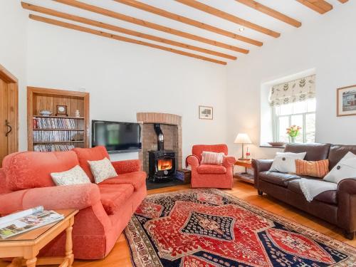 a living room with two couches and a fireplace at Ty Menyn in Mathry