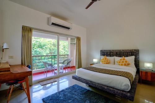 a bedroom with a large bed and a balcony at Private Pool 3BHK Villa near Candolim in Goa