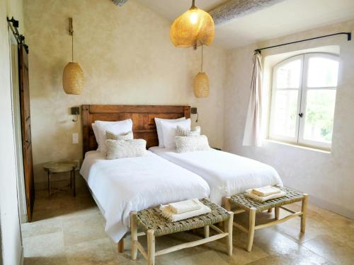 a bedroom with two beds and a window at Stunning Stone House With Pool Near Gordes in Gordes