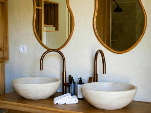 two sinks in a bathroom with two mirrors at Stunning Stone House With Pool Near Gordes in Gordes
