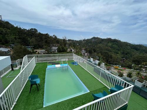 a balcony with a swimming pool and chairs at Munnar Peak Paradise in Devikolam
