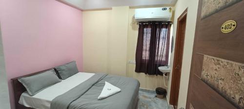 a small bedroom with a bed and a window at Hotel O Laxmi Grand in Dhundgol