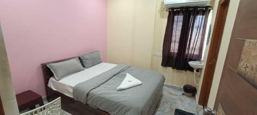 a small bedroom with a bed with a white pillow at Hotel O Laxmi Grand in Dhundgol