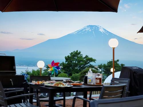 a table with food and a mountain in the background at Godere hotel Fujisanakako Tabist in Yamanakako