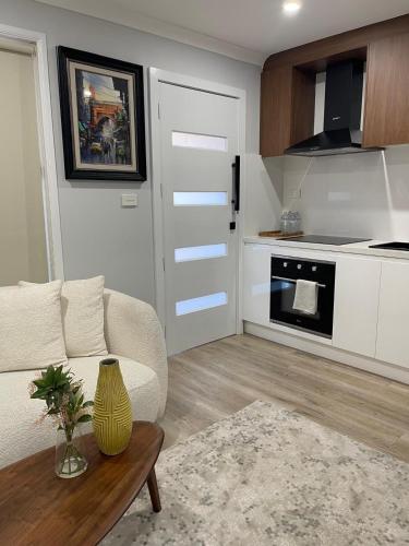 a living room with a couch and a kitchen at Kellyville Ridge 2 Bedroom Granny Flat in Glenwood