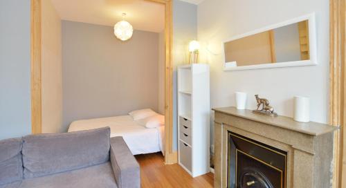 un salon avec un canapé et une cheminée dans l'établissement Appart' Duguesclin, à Lyon