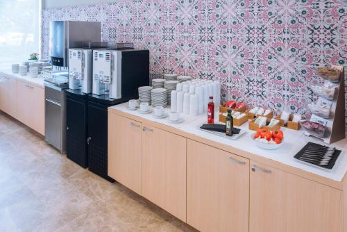 a kitchen with a counter with aasteryasteryasteryasteryasteryasteryasteryasteryastery at Aparthotel Cye Holiday Centre in Salou