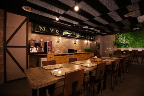 a restaurant with tables and chairs and a bar at NYS Loft Hotel in Taipei