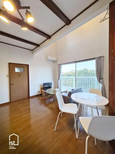 a living room with a table and chairs and a large window at Designer Island Villa with Panoramic Sea Views in Bizen