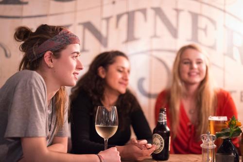 three women sitting at a table with a glass of wine at The Millers Arms Inn in Canterbury