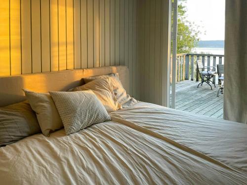 a bed in a bedroom with a view of a deck at Romantic Summer House On Orust in Stillingsön
