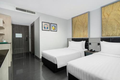 a hotel room with two beds and a kitchen at Garner Hotel Pattaya Central by IHG in Pattaya