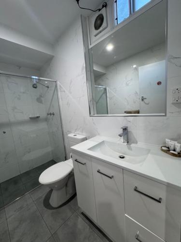 a bathroom with a toilet and a sink and a shower at The Sands Motel Adelaide in Adelaide
