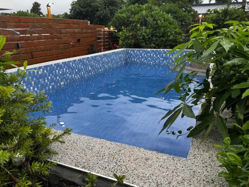 a swimming pool with blue water in a garden at 寧靜の家A區14人Villa專暑獨棟隱私無憂 in Hengchun