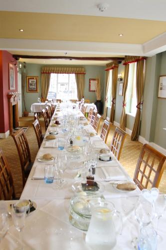 a long table with plates and wine glasses on it at Royal Hotel in Deal