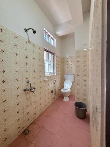 a bathroom with a toilet and a window at Victus Emporium in Guwahati