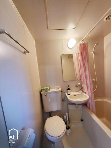 a small bathroom with a toilet and a sink at Affordable Island Villa with Sea Views Great Value Stay in Bizen