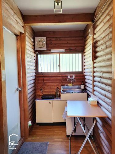 a kitchen with wooden walls and a table in a room at Affordable Island Villa with Sea Views Great Value Stay in Bizen