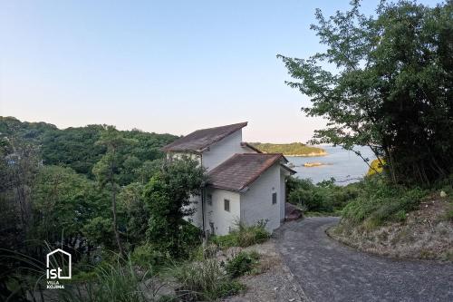 a small white house on the side of a road at ist villa 05 Mountain Hideout Sleeps 3 in Wada