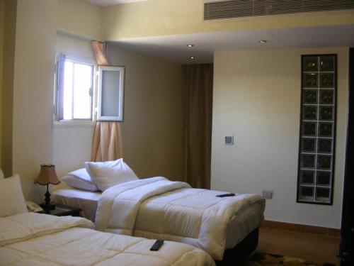 a hotel room with two beds and a window at Best View Pyramids Hotel in Cairo