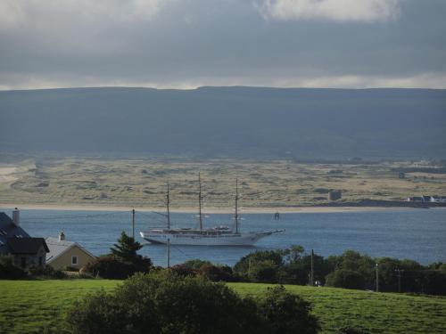 a large boat in the water next to a house at On the Rocks B&B in Greencastle