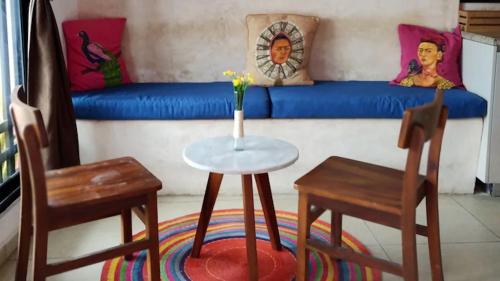 a living room with a table and two chairs and a couch at Habitacion3 Sencilla con baño propio in Mérida