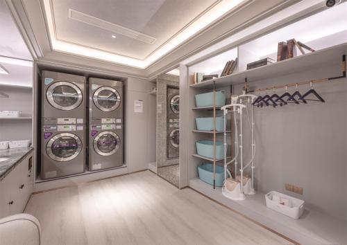 a laundry room with three washing machines and shelves at Mercure Hotel in Xi'an