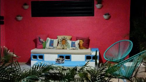 a couch in front of a red wall at Habitacion3 Sencilla con baño propio in Mérida