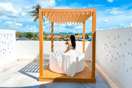 a woman sitting in a gazebo on a roof at The Pool Space - ICONIC Pool Villa in Ban Huai Yai
