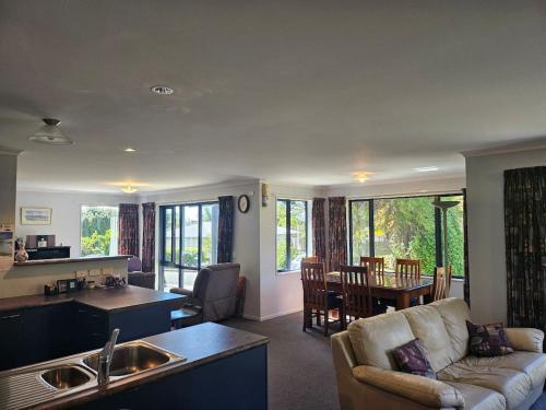 a kitchen and living room with a couch and a table at Fisherman's Friend - a spacious family beach home in Pohara
