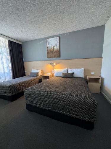 a hotel room with two beds and a window at The Sands Motel Adelaide in Adelaide