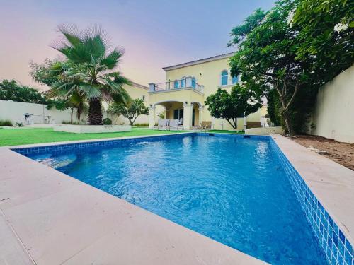 a swimming pool in front of a house at Luxury 3BR Private Pool Villa and Elaborate Gardens in Dubai