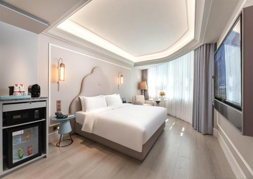 a bedroom with a white bed and a large window at Mercure Hotel in Xi'an