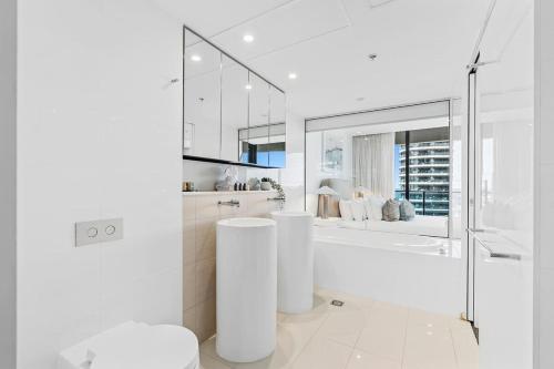 a white bathroom with a tub and a shower at Luxurious 2-Bed Designer Retreat at Oracle Resort in Gold Coast