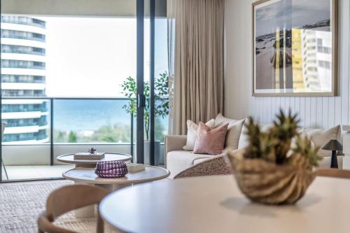 a living room with a couch and a table at Luxurious 2-Bed Designer Retreat at Oracle Resort in Gold Coast