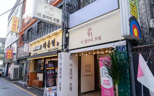 a building with signs on the side of a street at 더 갤러리 호텔 in Suwŏn-yŏk