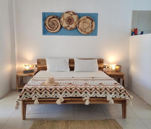 a bedroom with a large bed with two tables and a painting at Paje Beach Zanzibar Private Luxury Villa with pool AC WIFI TV 90m walk to beach central location walk to shops bars & restaurants in Paje