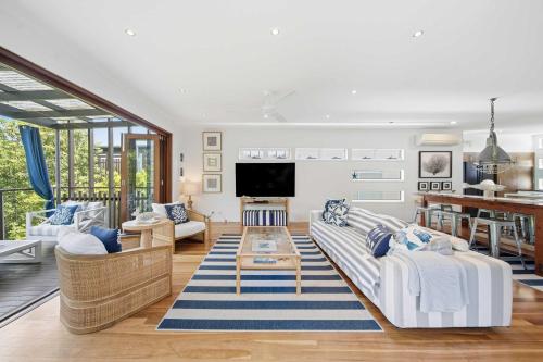 a living room with white furniture and a tv at Family Beach House at Twin Waters Resort in Twin Waters