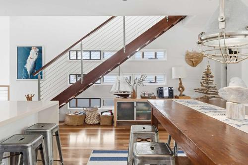 a kitchen with a large wooden counter and stools at Family Beach House at Sebel Twin Waters Resort in Twin Waters