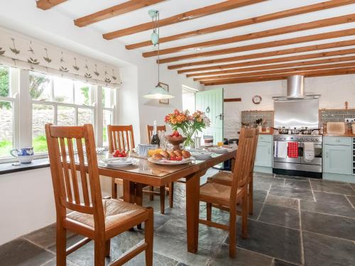 a dining room with a wooden table and chairs at Ty Menyn in Mathry