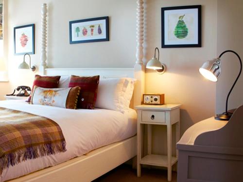1 dormitorio con 1 cama con 2 lámparas y mesita de noche en The Plough Inn & Cottages, en Scarborough