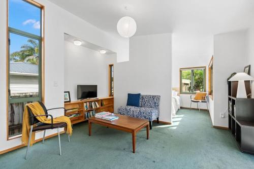 a living room with a couch and a table at Water's Edge Stay in Central Whangarei in Whangarei